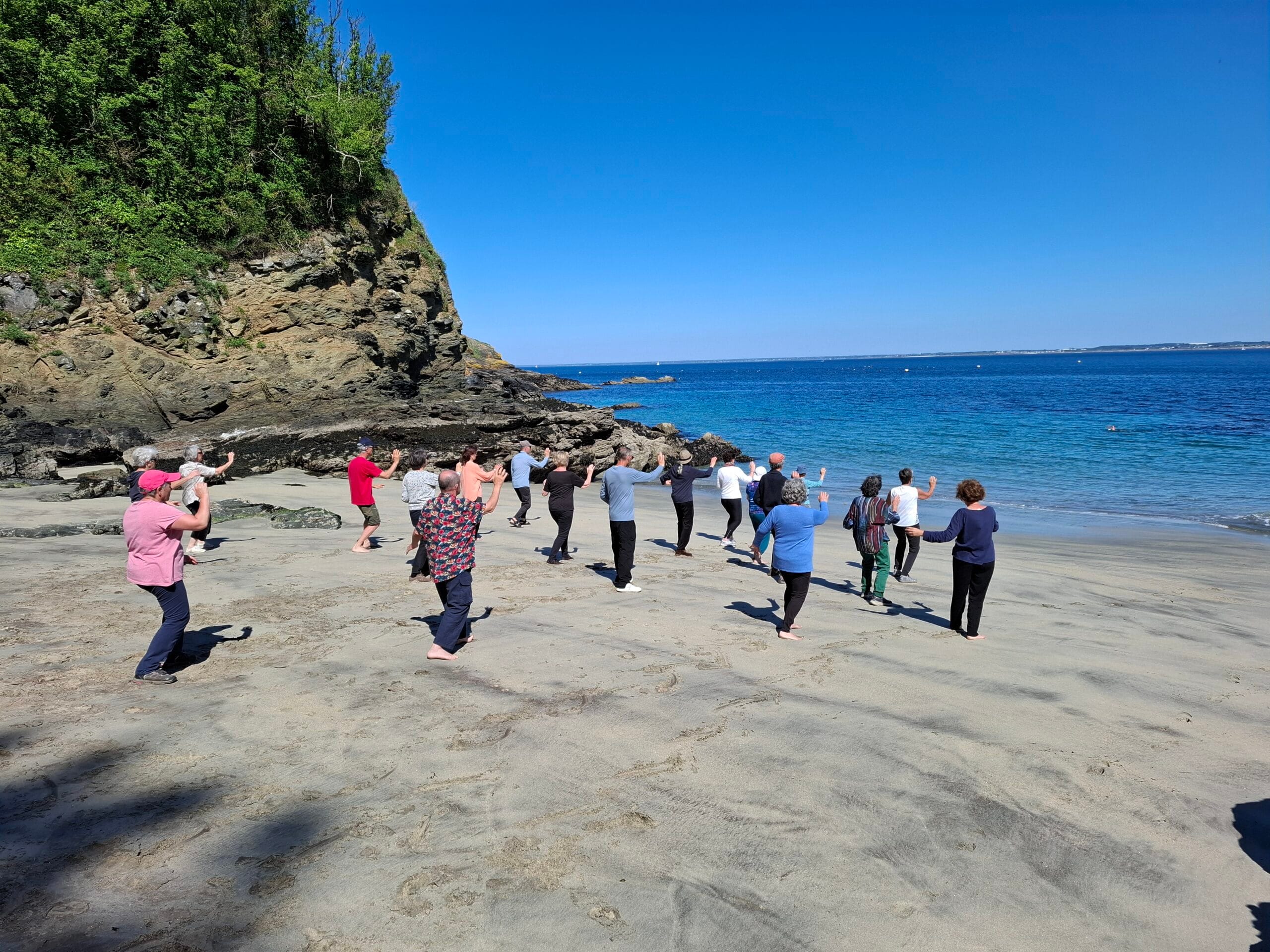 Groupe pratiquant le tai chi sur la plage
